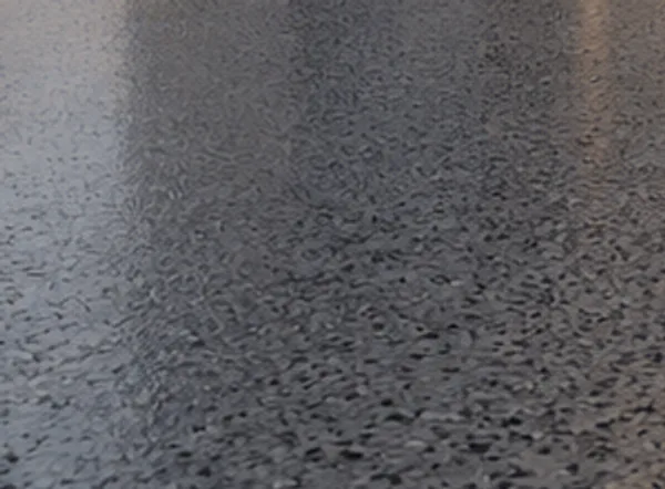 Worn grey concrete surface with an old sealer sheen